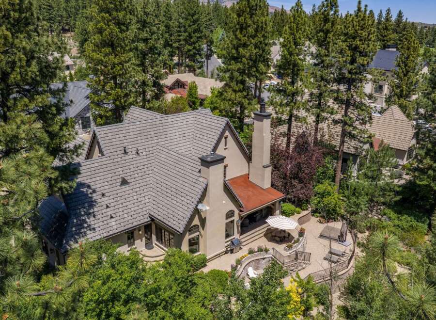 Nestled amidst towering pine trees, this stunning property offers a luxurious retreat with an expansive outdoor living space.
