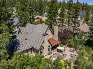 Nestled amidst towering pine trees, this stunning property offers a luxurious retreat with an expansive outdoor living space.