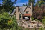 Experience luxurious mountain living in this stunning home, featuring a covered patio with an outdoor dining area perfect for entertaining.