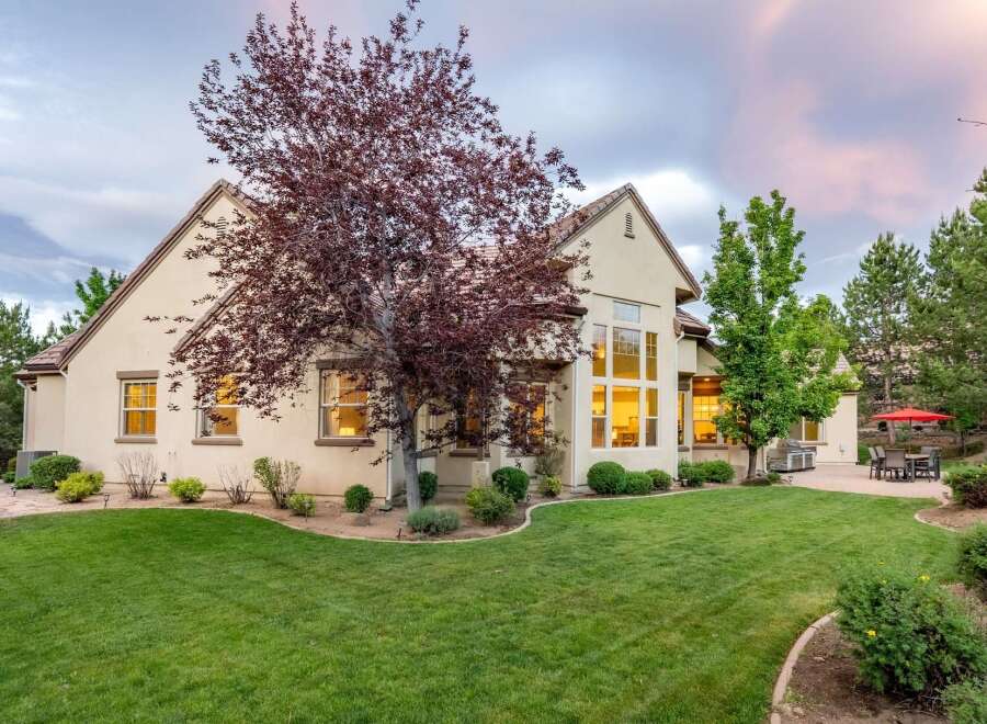 This stunning home features a spacious backyard with a lush green lawn, perfect for outdoor activities and entertaining.