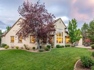 This stunning home features a spacious backyard with a lush green lawn, perfect for outdoor activities and entertaining.