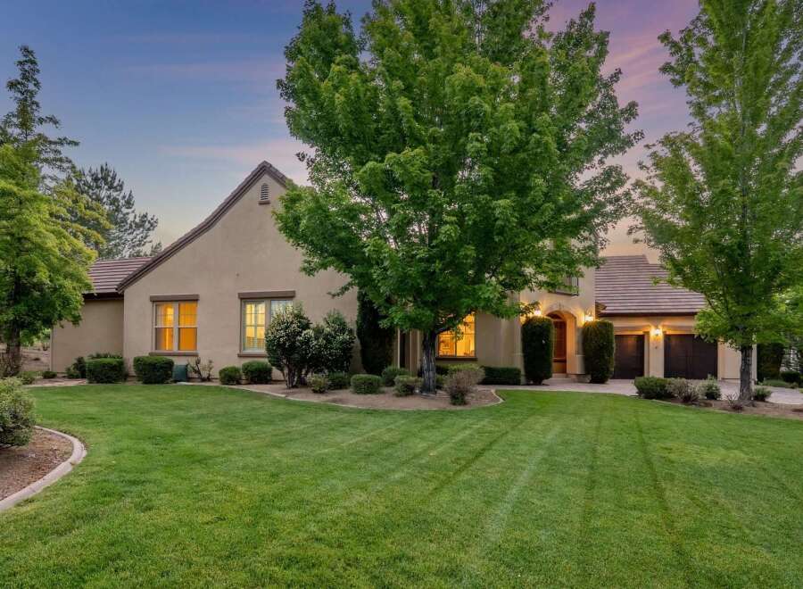 This stunning home boasts a beautifully manicured lawn and mature trees, creating a serene and inviting atmosphere.