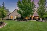 This stunning home boasts a beautifully manicured lawn and mature trees, creating a serene and inviting atmosphere.