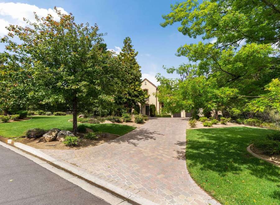 Welcome to this stunning property featuring a beautifully paved driveway leading to an elegant home.