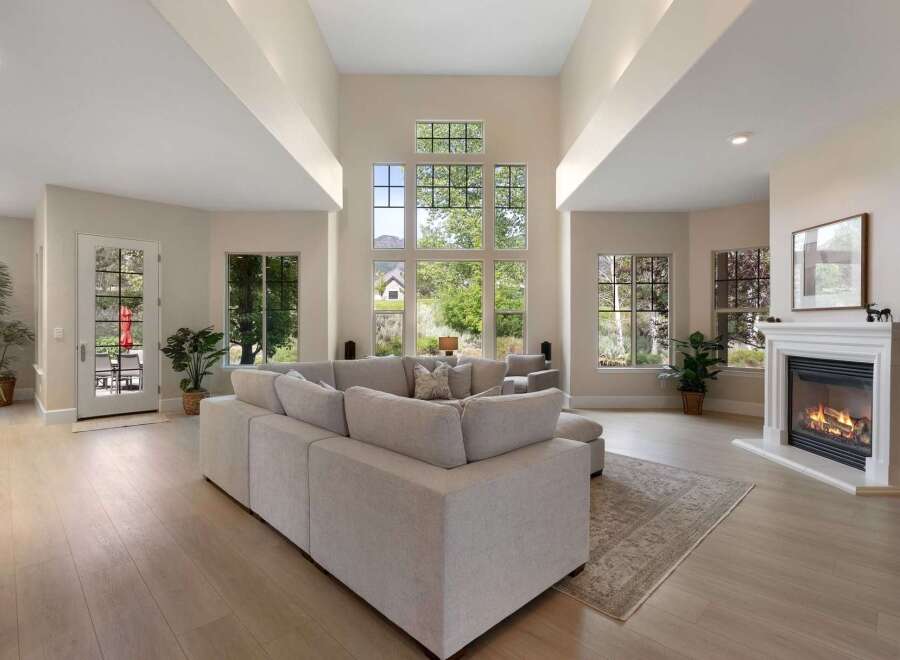 Experience luxury living in this stunning great room, featuring a soaring vaulted ceiling and expansive windows that flood the space with natural light.