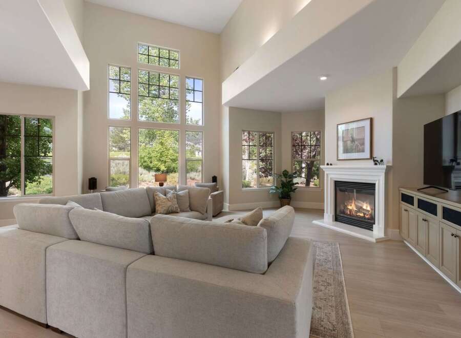 Experience luxurious living in this spacious great room, featuring soaring ceilings and an abundance of natural light from floor-to-ceiling windows.