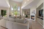 Experience luxurious living in this spacious great room, featuring soaring ceilings and an abundance of natural light from floor-to-ceiling windows.