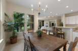 This spacious dining area features a large, rustic wooden table perfect for family gatherings, complemented by comfortable seating and a charming chandelier.
