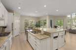 Experience the epitome of modern living in this stunning kitchen, featuring a spacious island with granite countertops and a double sink.