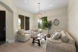 Step into this inviting living room, bathed in natural light from large windows overlooking lush greenery.