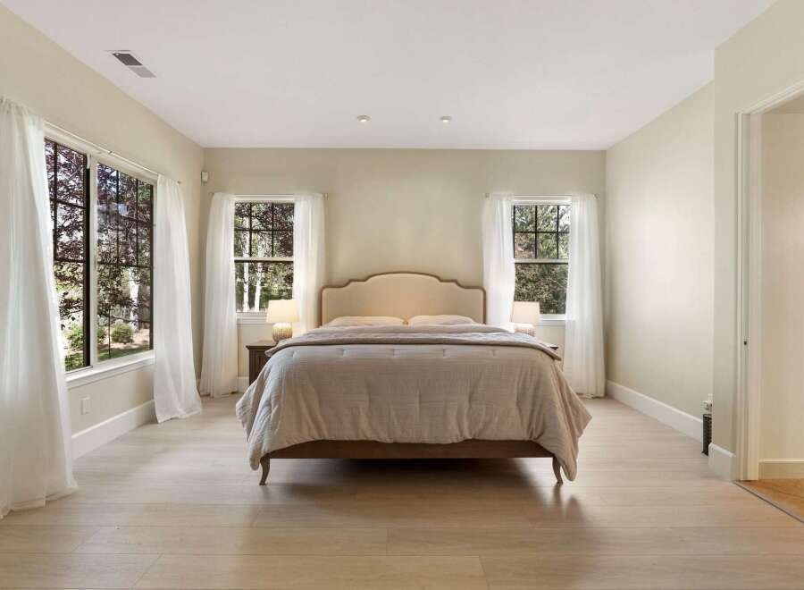 This serene bedroom features a plush king-sized bed with a stylish upholstered headboard, perfect for restful nights.
