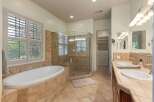 Indulge in luxury with this stunning bathroom featuring a spacious soaking tub and a separate glass-enclosed shower.