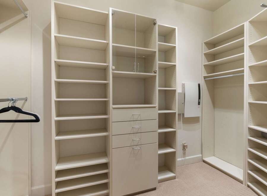 This spacious walk-in closet features ample shelving and storage solutions, perfect for organizing your wardrobe.