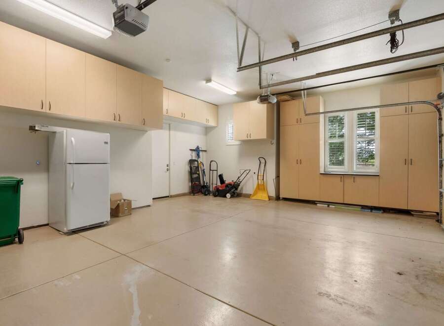 This spacious garage offers abundant storage with extensive built-in cabinetry, perfect for organizing tools and equipment.