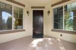 Step into elegance with this stunning dark wood front door, featuring intricate detailing and a decorative glass insert for a touch of sophistication.