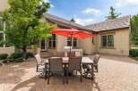 Enjoy outdoor living with this spacious patio featuring a dining set and a built-in grill, perfect for entertaining.