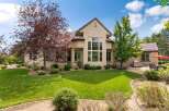 This stunning home boasts a beautifully landscaped yard with mature trees and a lush green lawn, perfect for outdoor enjoyment.