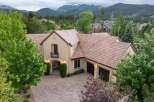 Experience luxury living in this stunning mountain-view estate, featuring a grand entrance with arched doorways and elegant exterior lighting.