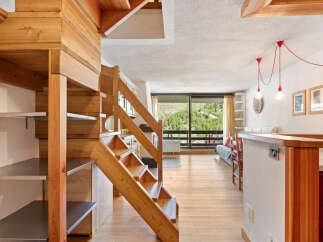 Experience mountain living in this charming wooden chalet-style apartment, featuring a unique lofted design with a beautiful wooden staircase and open-plan living space.