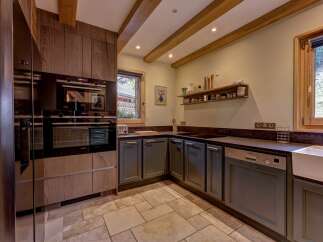Discover this charming kitchen featuring modern built-in Siemens appliances, including a sleek oven and microwave, complemented by dark wood cabinetry.