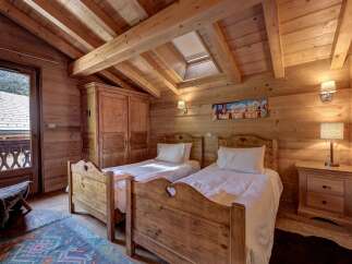 Experience rustic charm in this cozy mountain bedroom, featuring two twin beds with charming heart cutouts and crisp white linens.