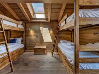 Experience cozy mountain living in this charming wooden bunk room, perfect for families or groups.