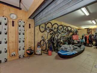 This spacious garage offers ample storage for all your recreational gear, featuring wall-mounted racks perfect for bicycles and outdoor equipment.