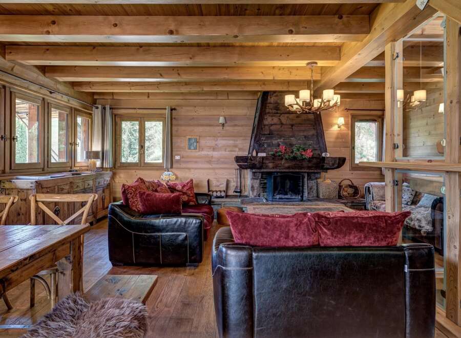 Experience rustic luxury in this charming log cabin living room, featuring a grand stone fireplace as the centerpiece.