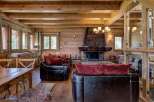 Experience rustic luxury in this charming log cabin living room, featuring a grand stone fireplace as the centerpiece.