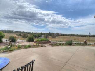 Enjoy breathtaking panoramic views from this expansive property, featuring a charming courtyard with a tiered fountain and lush landscaping.