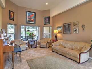 Step into this inviting living room, featuring a beautiful upright piano and plush leather seating perfect for relaxation.