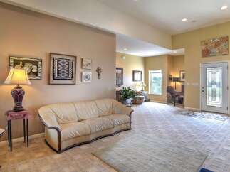 Step into this spacious living area featuring a comfortable leather sofa and a large, open floor plan perfect for entertaining.