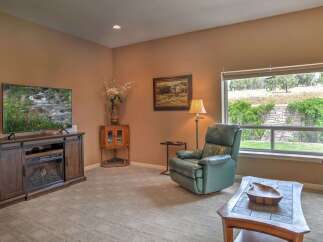Relax in this cozy living room featuring a large flat-screen TV and an electric fireplace, perfect for movie nights.