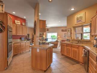 This spacious kitchen boasts beautiful light wood cabinetry and granite countertops, offering ample storage and workspace.