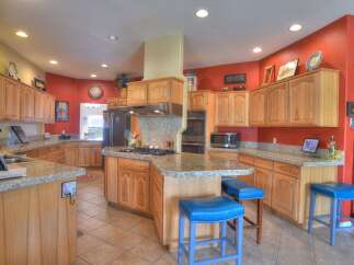 This spacious kitchen boasts custom wood cabinetry and granite countertops, perfect for any home chef.