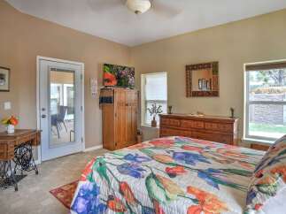 This charming bedroom features a vibrant floral comforter and a unique antique sewing machine desk, adding a touch of vintage flair.