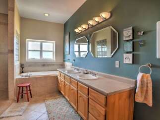 This spacious bathroom features a large soaking tub with a view from the window, perfect for relaxation.