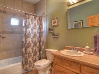 This bathroom features a clean and functional design with a tiled shower/tub combo and a convenient vanity.