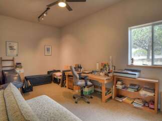 Discover a versatile home office space featuring a spacious wooden desk equipped for creative projects and work.