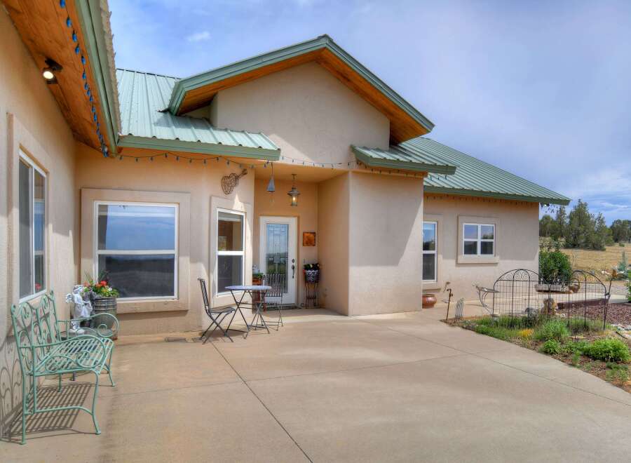 This charming home features a welcoming stucco exterior with a durable metal roof, perfect for any climate.