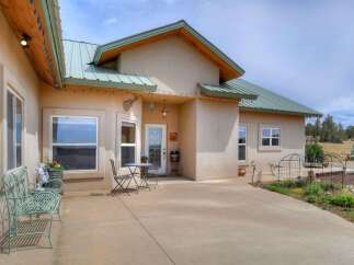 This charming home features a welcoming stucco exterior with a durable metal roof, perfect for any climate.