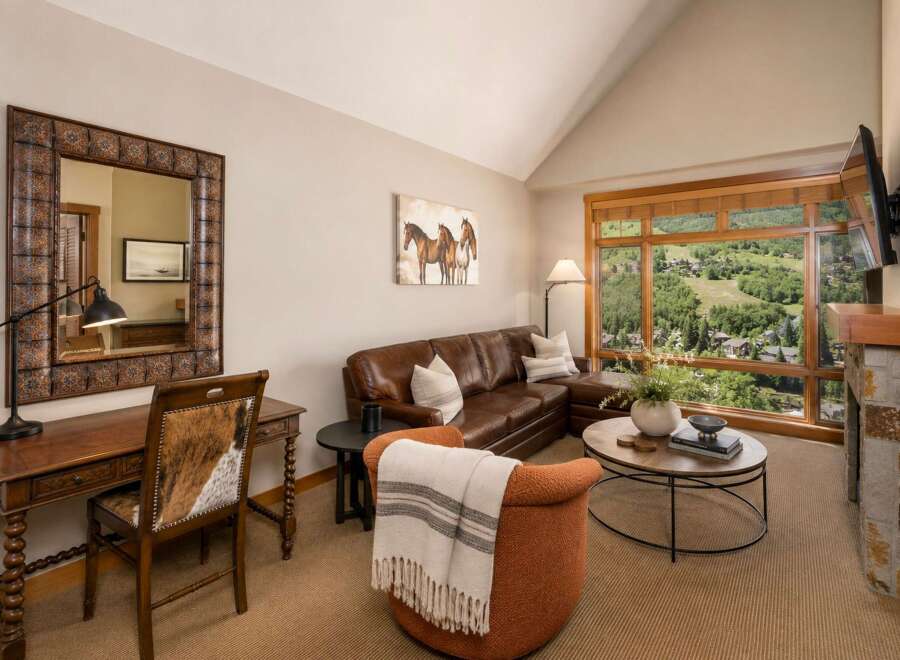 Experience luxury living with this stunning living room featuring a plush leather sectional sofa and a cozy accent chair, perfect for relaxing.