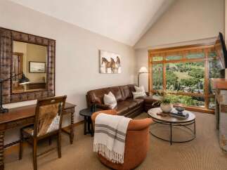Experience luxury living with this stunning living room featuring a plush leather sectional sofa and a cozy accent chair, perfect for relaxing.