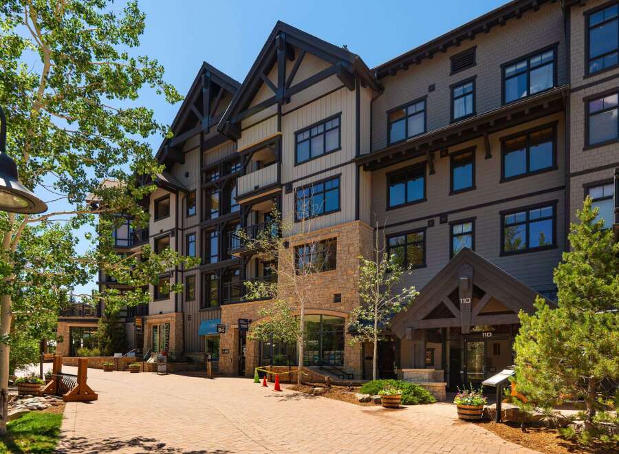 Discover luxury living in this stunning multi-story building featuring a blend of modern and rustic architecture.