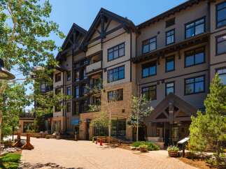 Discover luxury living in this stunning multi-story building featuring a blend of modern and rustic architecture.