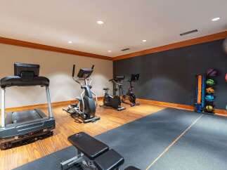 Equip your home gym with this comprehensive fitness setup, featuring a treadmill, elliptical, and stationary bikes for a complete cardio workout.