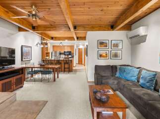 Experience comfortable living in this inviting open-concept space, featuring a modern kitchen with ample cabinetry and a breakfast bar, perfect for casual dining.