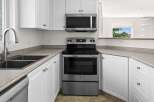 Discover this charming kitchen featuring sleek stainless steel appliances, including a modern microwave and a spacious oven.