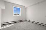This spacious room features a large window offering abundant natural light and a view of the outdoors.