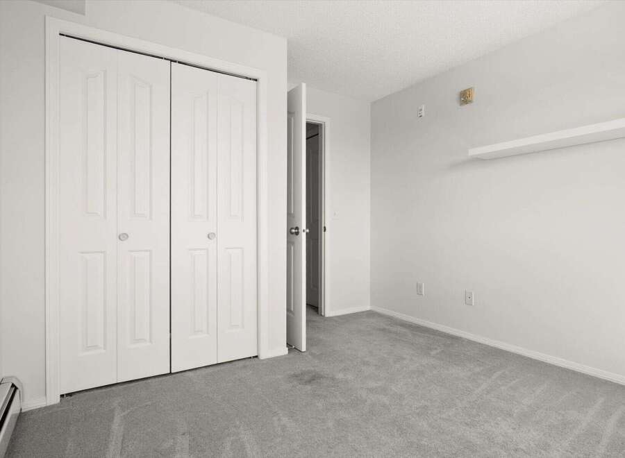 This spacious room features a large white bi-fold closet, perfect for ample storage.